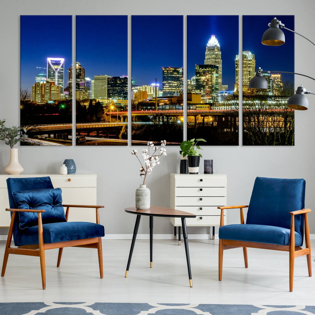 The Charlotte City Lights Night Blue Skyline Cityscape View Wall Art Canvas Print, showcasing an illuminated city skyline at night, is printed on museum-quality canvas with a UV-protective coating. Enhance your space with this stunning piece and enjoy free shipping with your purchase.