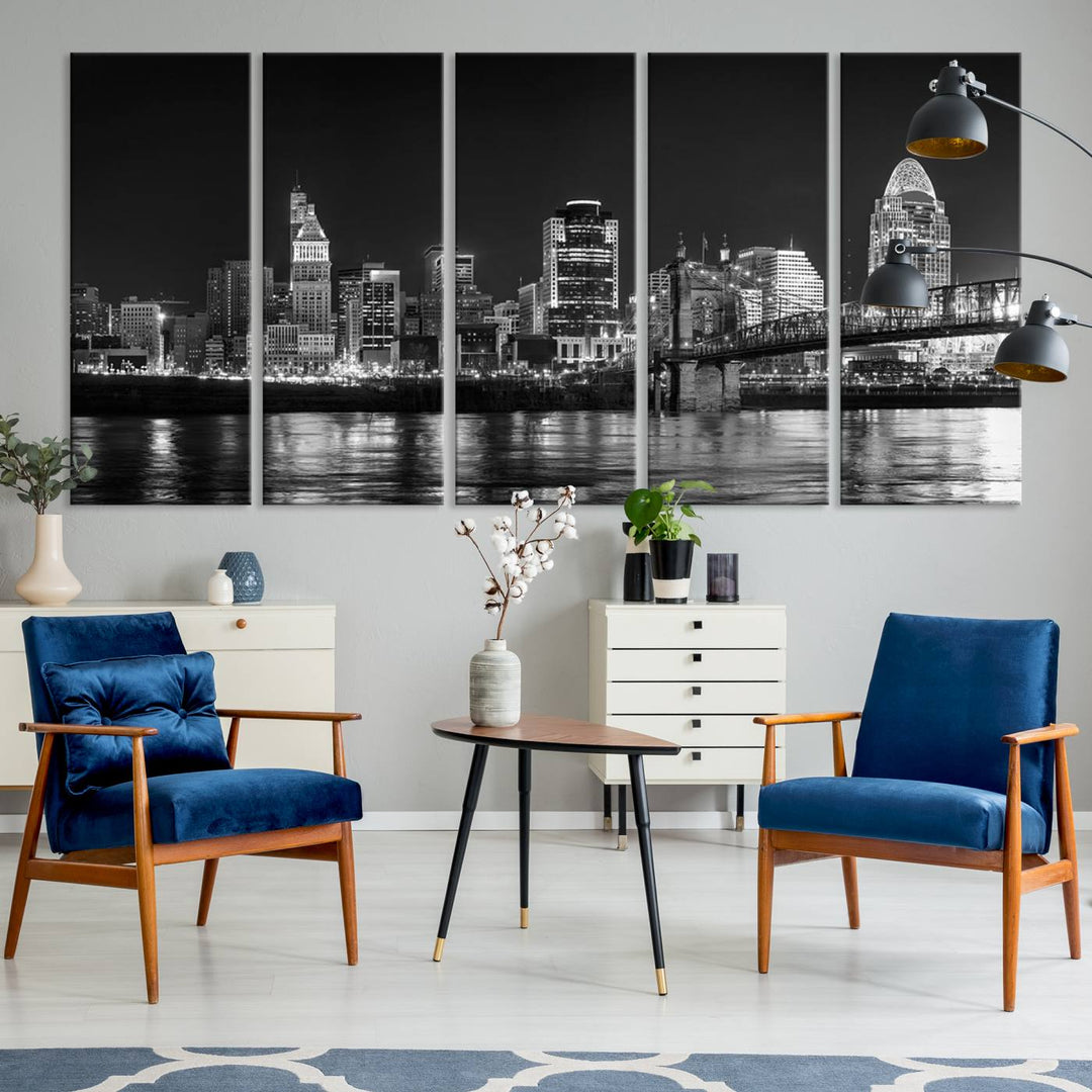 The Cincinnati City Lights Skyline Black and White Wall Art Cityscape Canvas Print elegantly adorns a modern living room. This museum-quality canvas triptych of a city skyline is enhanced by hand-assembled frames for added finesse, and you can enjoy free shipping on this stunning home addition.