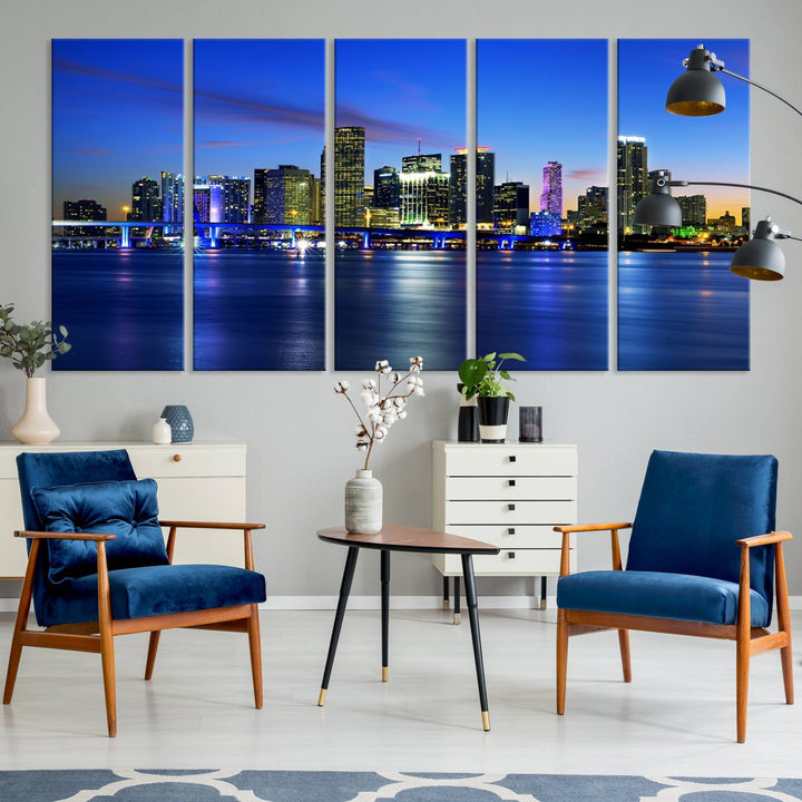 The modern living room showcases a striking Miami Blue Night Wall Art canvas print on the wall. The artwork is gallery wrapped on museum-quality canvas, ensuring durability and elegance.