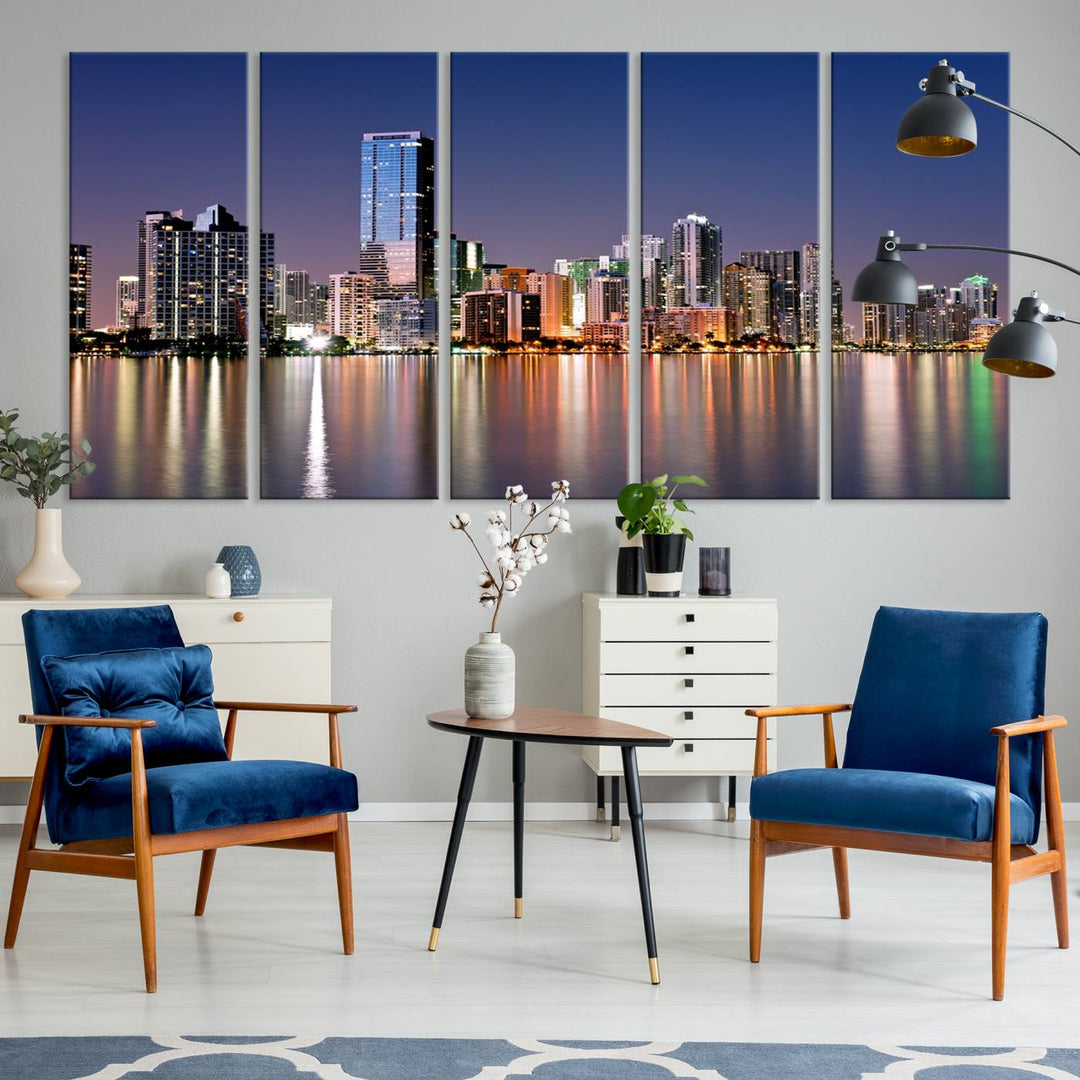 The Miami Skyline Canvas Wall Art Print showcases a vibrant night cityscape and beautifully captures the dazzling colorful lights reflecting on the water. This ready-to-hang triptych adorns the wall, creating a stunning visual centerpiece.