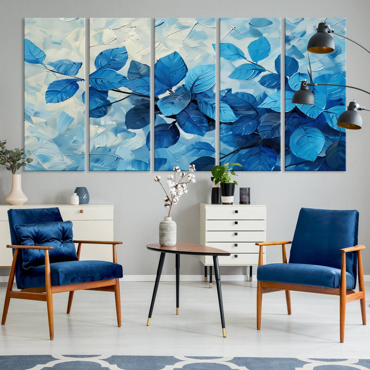 The contemporary living room is highlighted by the Abstract Blue Leaf Wall Art Canvas Print on the wall. The hand-assembled framed art enhances the room's vibrant decor, crafting a gallery-worthy ambience.