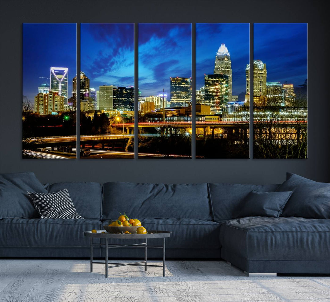 A modern living room highlighted by the "Charlotte City Lights Cloudy Blue Night Skyline Cityscape View" wall art canvas print, crafted on museum-quality canvas with UV-protective coating.