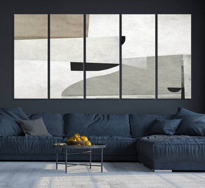 The Brown Gray Figures Abstract Wall Art Canvas Print is displayed as a triptych on a dark wall. The piece is gallery wrapped, offering a seamless finish and enhanced durability due to its UV-protective coating.