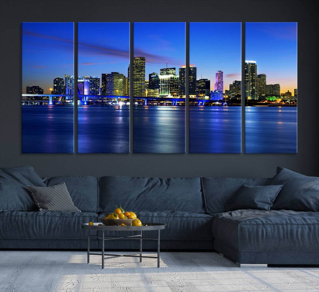 The modern living room showcases a striking Miami Blue Night Wall Art canvas print on the wall. The artwork is gallery wrapped on museum-quality canvas, ensuring durability and elegance.