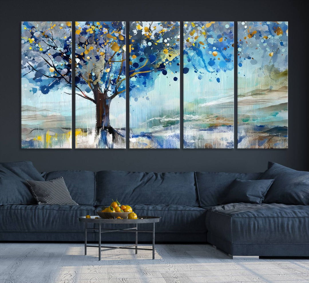 A modern living room features a three-panel Watercolor Style Abstract Tree Printing Wall Art Canvas in vibrant blue and yellow, crafted on museum-quality material.