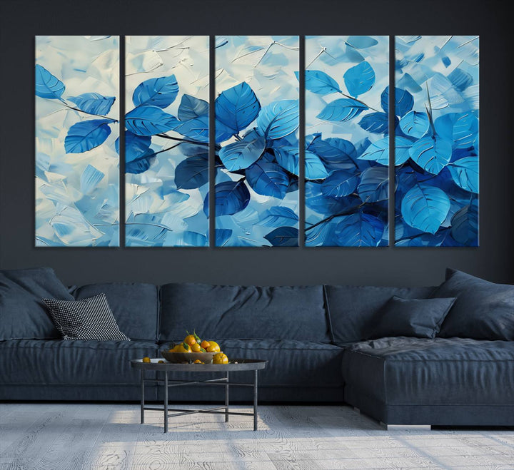 The contemporary living room is highlighted by the Abstract Blue Leaf Wall Art Canvas Print on the wall. The hand-assembled framed art enhances the room's vibrant decor, crafting a gallery-worthy ambience.