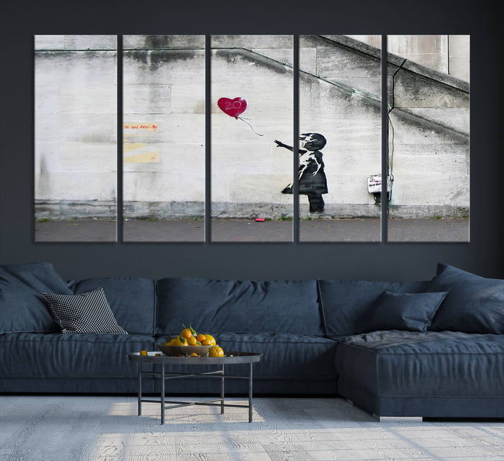 The "Girl with a Balloon Banksy Street Graffiti Art Canvas Print" is a gallery-quality wall art piece that features an image of a girl releasing a heart-shaped balloon. Handmade in the USA, this canvas artwork brings charm and emotion to any room.