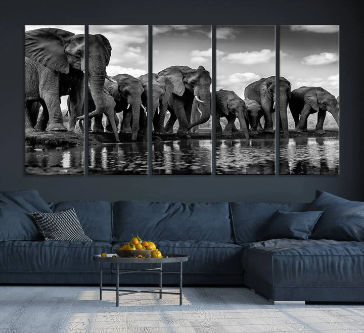 A stunning "Wall Art Animal Canvas Print" featuring a black and white photo of a herd of elephants drinking water is elegantly displayed, gallery wrapped on museum-quality canvas.