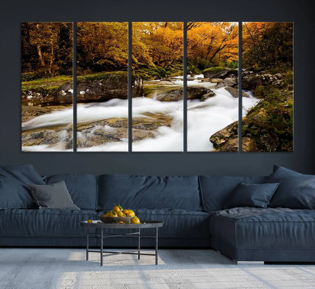 The living room is adorned with the "Wall Art Waterfall Canvas Print River in Forest in Autumn," a triptych on museum-quality canvas showcasing a flowing river surrounded by autumn trees. This ready-to-hang artwork features a UV-protective coating to ensure enduring vibrancy.