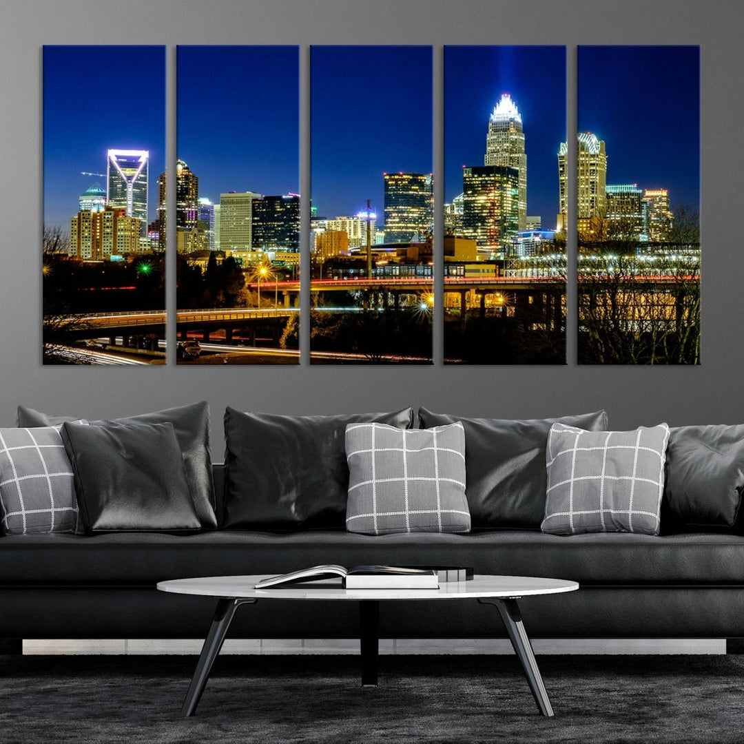 The Charlotte City Lights Night Blue Skyline Cityscape View Wall Art Canvas Print, showcasing an illuminated city skyline at night, is printed on museum-quality canvas with a UV-protective coating. Enhance your space with this stunning piece and enjoy free shipping with your purchase.