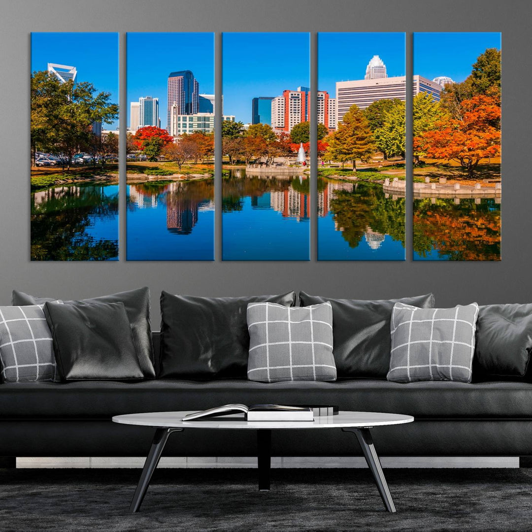 The "Charlotte City Autumn Morning Blue Skyline Cityscape View Wall Art Canvas Print" showcases a cityscape with vibrant autumn trees reflected in a lake. Its gallery-wrapped edges add depth to the scene, while the UV-protective coating ensures lasting brilliance.