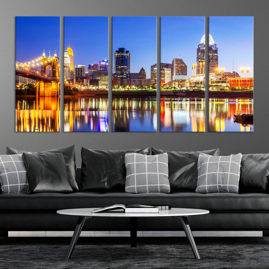 The "Cincinnati City Lights Night Skyline Cityscape View Wall Art Canvas Print" is a gallery-wrapped, museum-quality canvas illustrating a lit-up bridge and skyline at night. Enhanced with a UV-protective coating, this piece ensures lasting vibrancy.