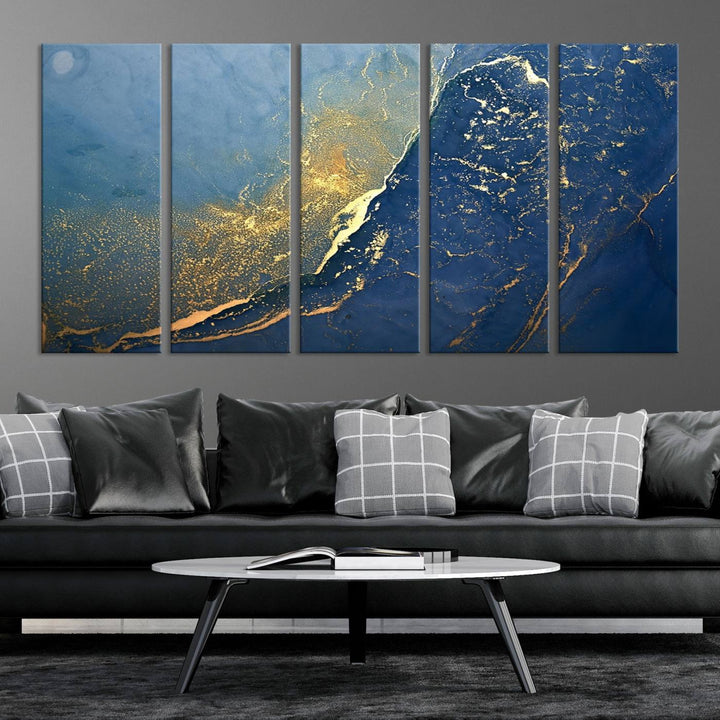 The Navy Blue Yellow Twinkle Wall Art Canvas Print, featuring an abstract design in gold and blue, enhances a modern living room as it adorns a white wall with its gallery-wrapped, museum-quality canvases for an exquisite touch.