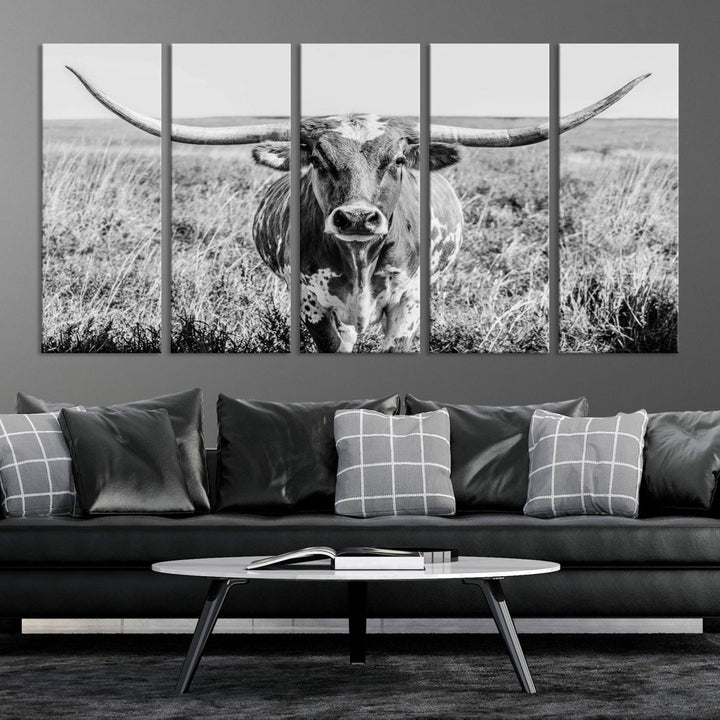 The Texas Cow Longhorn Wall Art Canvas Print is a black and white triptych depicting a cow in a field. It is crafted with museum-quality canvas and features a UV-protective coating.