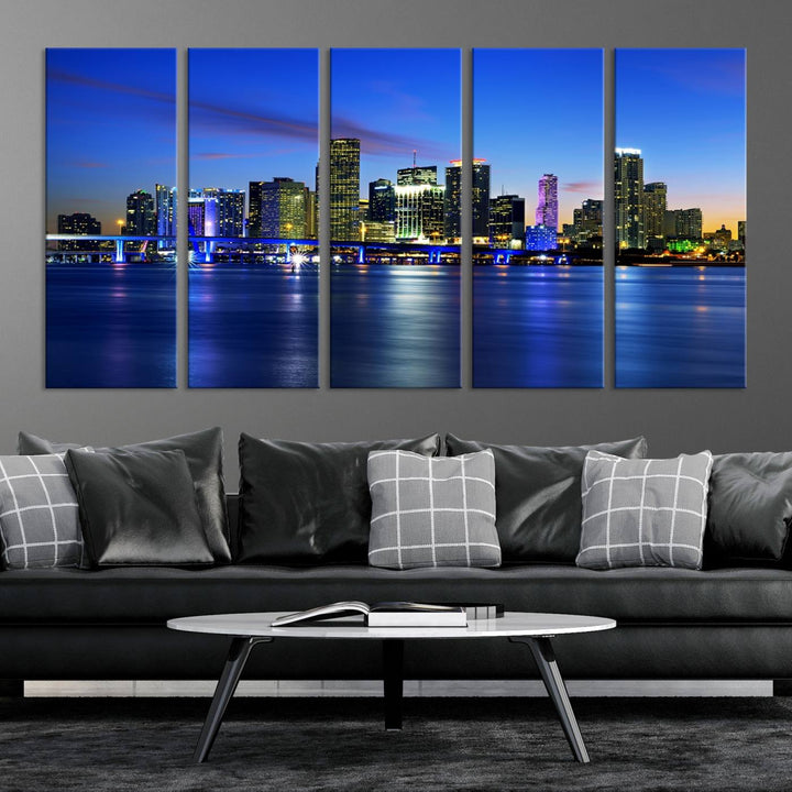 The modern living room showcases a striking Miami Blue Night Wall Art canvas print on the wall. The artwork is gallery wrapped on museum-quality canvas, ensuring durability and elegance.