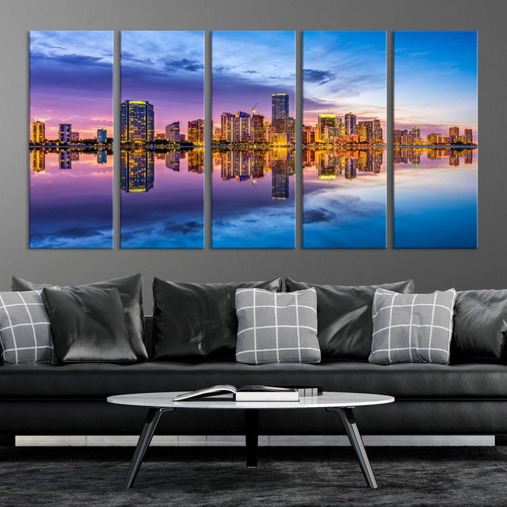 The Miami City Wall Art Canvas Print, featuring a three-panel depiction of a city skyline at sunset reflected in water, beautifully enhances the wall. Made with museum-quality canvas and a UV-protective coating, it comes ready to hang.