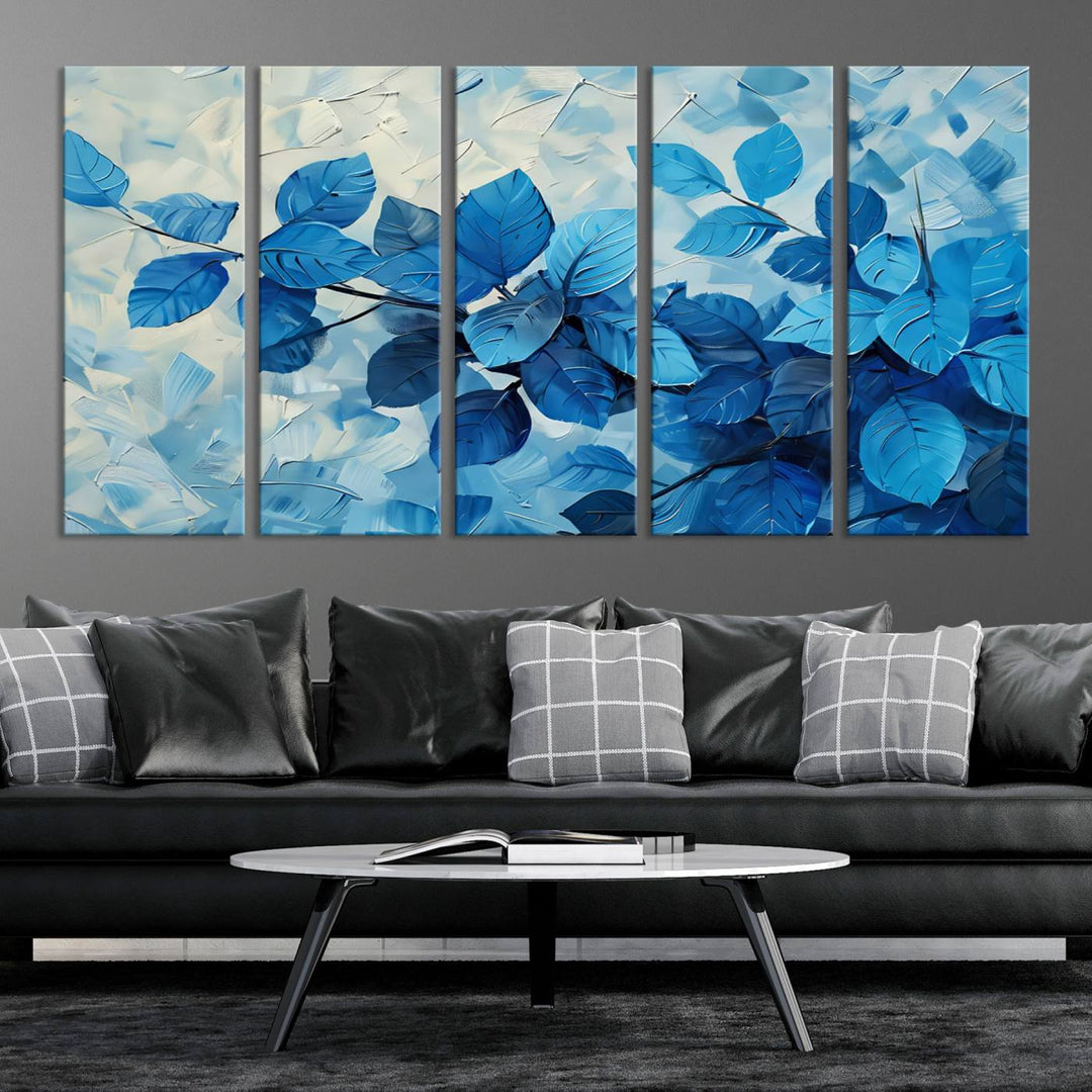 The contemporary living room is highlighted by the Abstract Blue Leaf Wall Art Canvas Print on the wall. The hand-assembled framed art enhances the room's vibrant decor, crafting a gallery-worthy ambience.