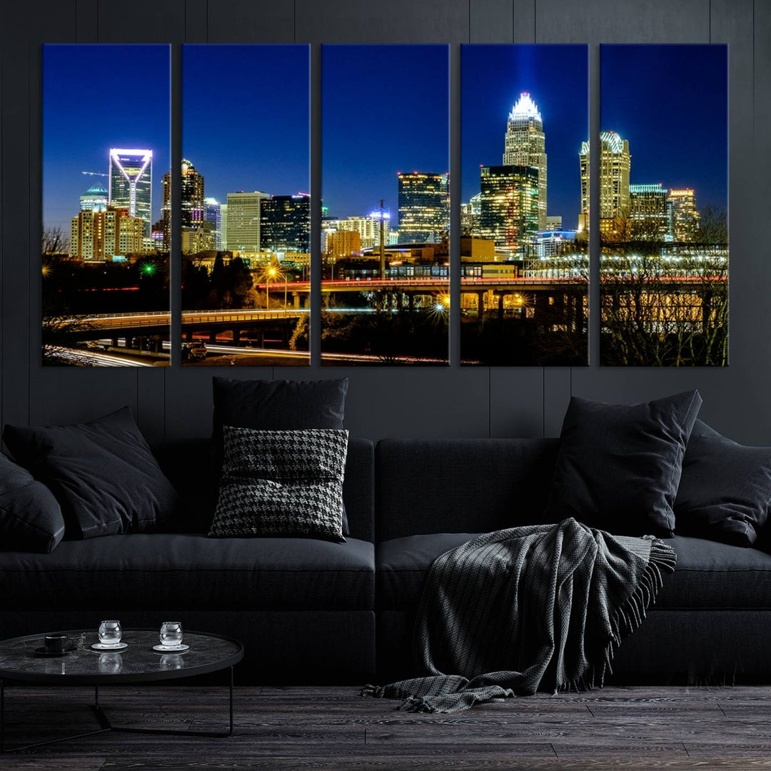 The Charlotte City Lights Night Blue Skyline Cityscape View Wall Art Canvas Print, showcasing an illuminated city skyline at night, is printed on museum-quality canvas with a UV-protective coating. Enhance your space with this stunning piece and enjoy free shipping with your purchase.