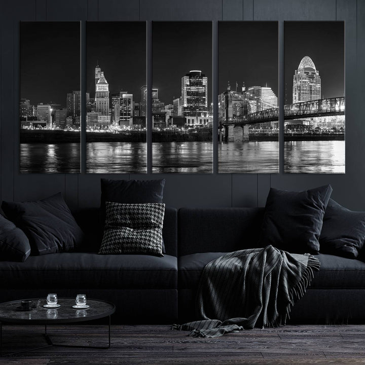 The Cincinnati City Lights Skyline Black and White Wall Art Cityscape Canvas Print elegantly adorns a modern living room. This museum-quality canvas triptych of a city skyline is enhanced by hand-assembled frames for added finesse, and you can enjoy free shipping on this stunning home addition.