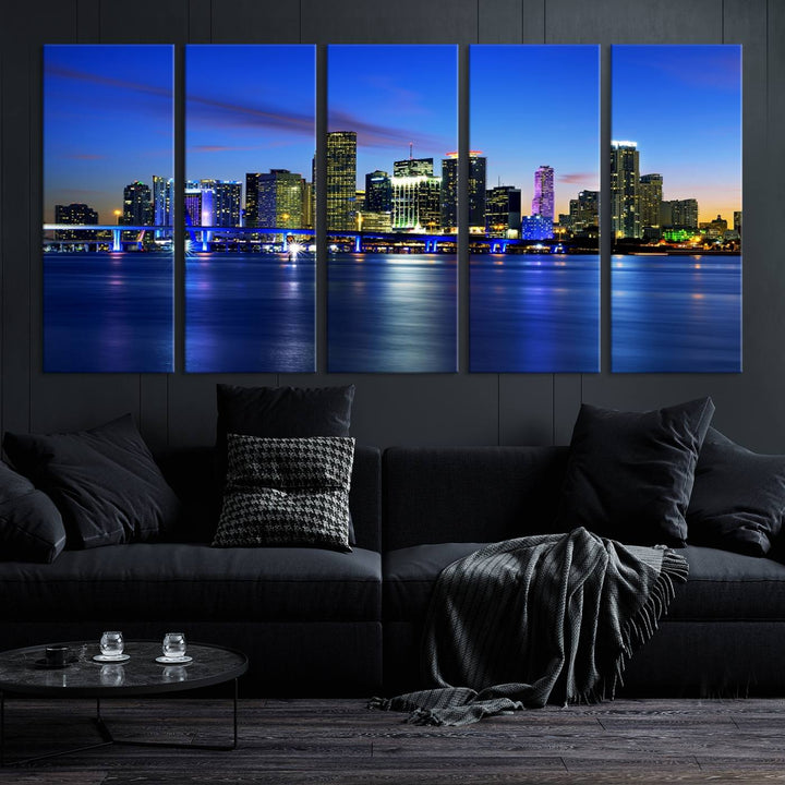 The modern living room showcases a striking Miami Blue Night Wall Art canvas print on the wall. The artwork is gallery wrapped on museum-quality canvas, ensuring durability and elegance.