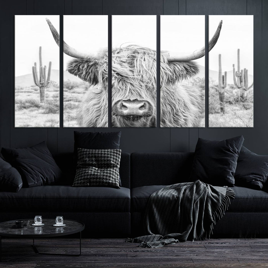 The "Rustic Charm | Cow Longhorn Black White Bighorn Wall Art Canvas Print" is a stunning triptych that showcases a highland cow with long horns set against a desert landscape with cacti in the background. This farmhouse wall art elevates any room into a rustic haven with its gallery-quality canvas.