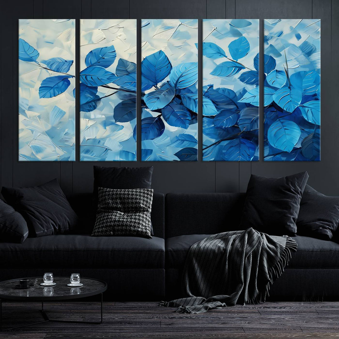 The contemporary living room is highlighted by the Abstract Blue Leaf Wall Art Canvas Print on the wall. The hand-assembled framed art enhances the room's vibrant decor, crafting a gallery-worthy ambience.