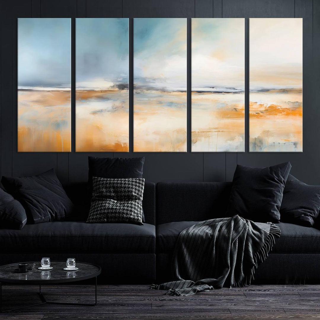 The Abstract Landscape Wall Art Canvas Print, featuring warm tones of orange and blue, is displayed on a dark wall.