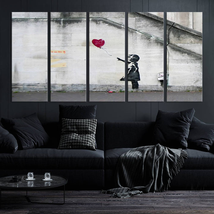 The "Girl with a Balloon Banksy Street Graffiti Art Canvas Print" is a gallery-quality wall art piece that features an image of a girl releasing a heart-shaped balloon. Handmade in the USA, this canvas artwork brings charm and emotion to any room.