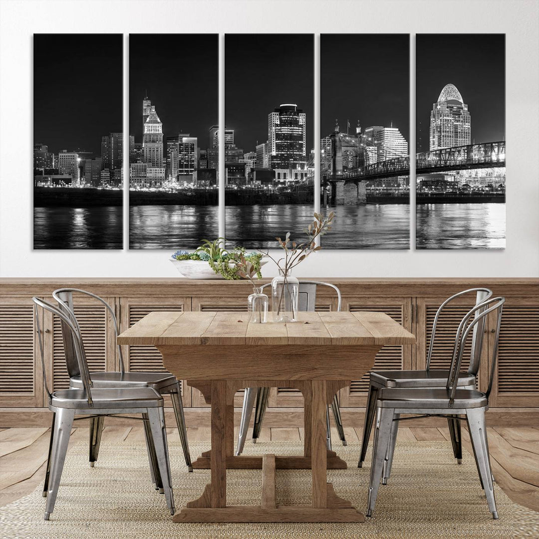 The Cincinnati City Lights Skyline Black and White Wall Art Cityscape Canvas Print elegantly adorns a modern living room. This museum-quality canvas triptych of a city skyline is enhanced by hand-assembled frames for added finesse, and you can enjoy free shipping on this stunning home addition.