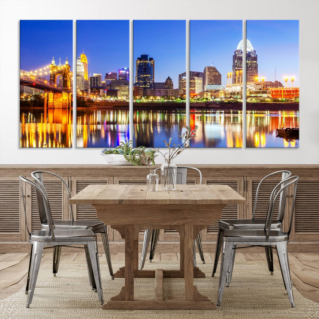 The "Cincinnati City Lights Night Skyline Cityscape View Wall Art Canvas Print" is a gallery-wrapped, museum-quality canvas illustrating a lit-up bridge and skyline at night. Enhanced with a UV-protective coating, this piece ensures lasting vibrancy.