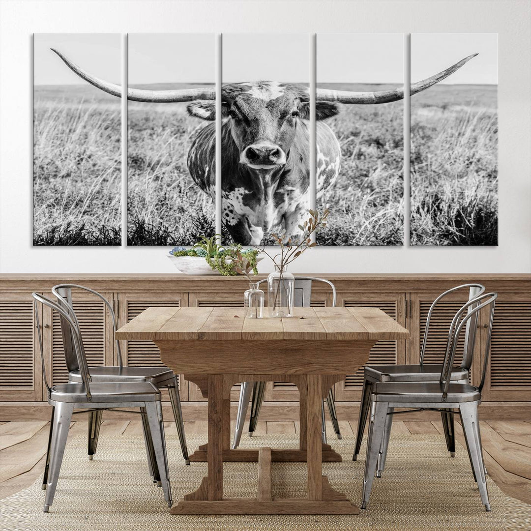 The Texas Cow Longhorn Wall Art Canvas Print is a black and white triptych depicting a cow in a field. It is crafted with museum-quality canvas and features a UV-protective coating.