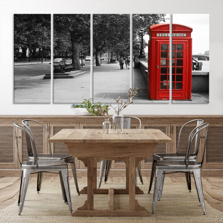 The London Phone Club Wall Art is a stunning piece that showcases a red telephone box set in a black and white street scene on museum-quality canvas. It is gallery wrapped with a UV-protective coating to preserve its vibrant charm.