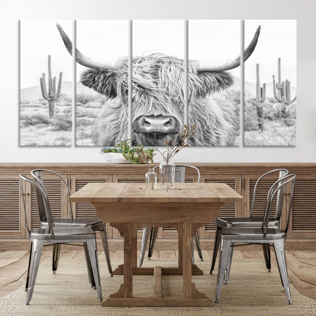 The "Rustic Charm | Cow Longhorn Black White Bighorn Wall Art Canvas Print" is a stunning triptych that showcases a highland cow with long horns set against a desert landscape with cacti in the background. This farmhouse wall art elevates any room into a rustic haven with its gallery-quality canvas.