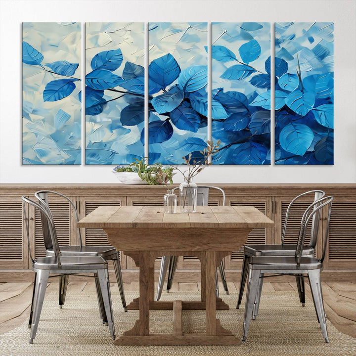 The contemporary living room is highlighted by the Abstract Blue Leaf Wall Art Canvas Print on the wall. The hand-assembled framed art enhances the room's vibrant decor, crafting a gallery-worthy ambience.