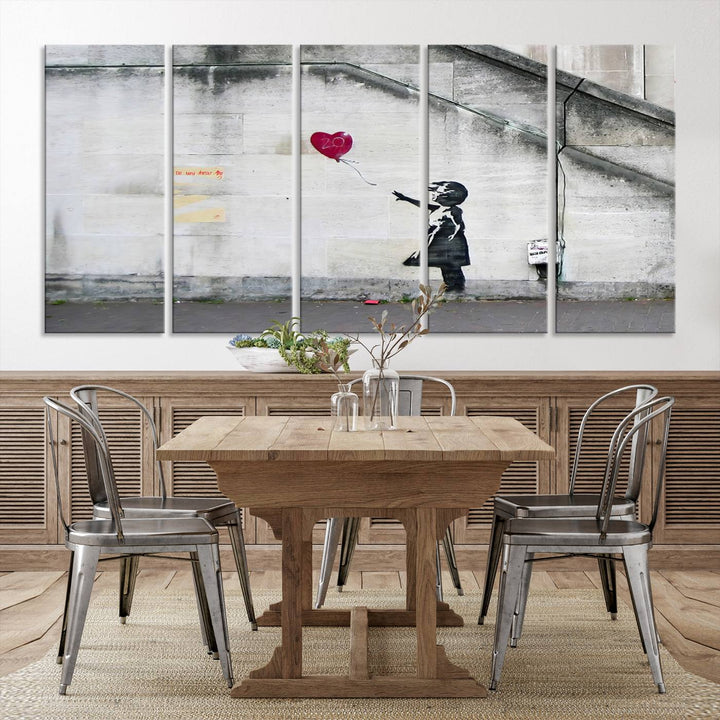 The "Girl with a Balloon Banksy Street Graffiti Art Canvas Print" is a gallery-quality wall art piece that features an image of a girl releasing a heart-shaped balloon. Handmade in the USA, this canvas artwork brings charm and emotion to any room.