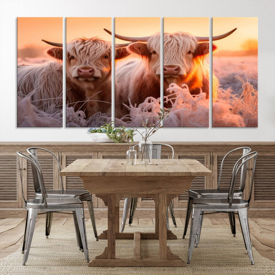 The "Highland Cows at Sunrise Wall Art Canvas Set" beautifully captures a serene and rustic farmhouse aesthetic, portraying two Highland cows in a frosty landscape at sunrise.