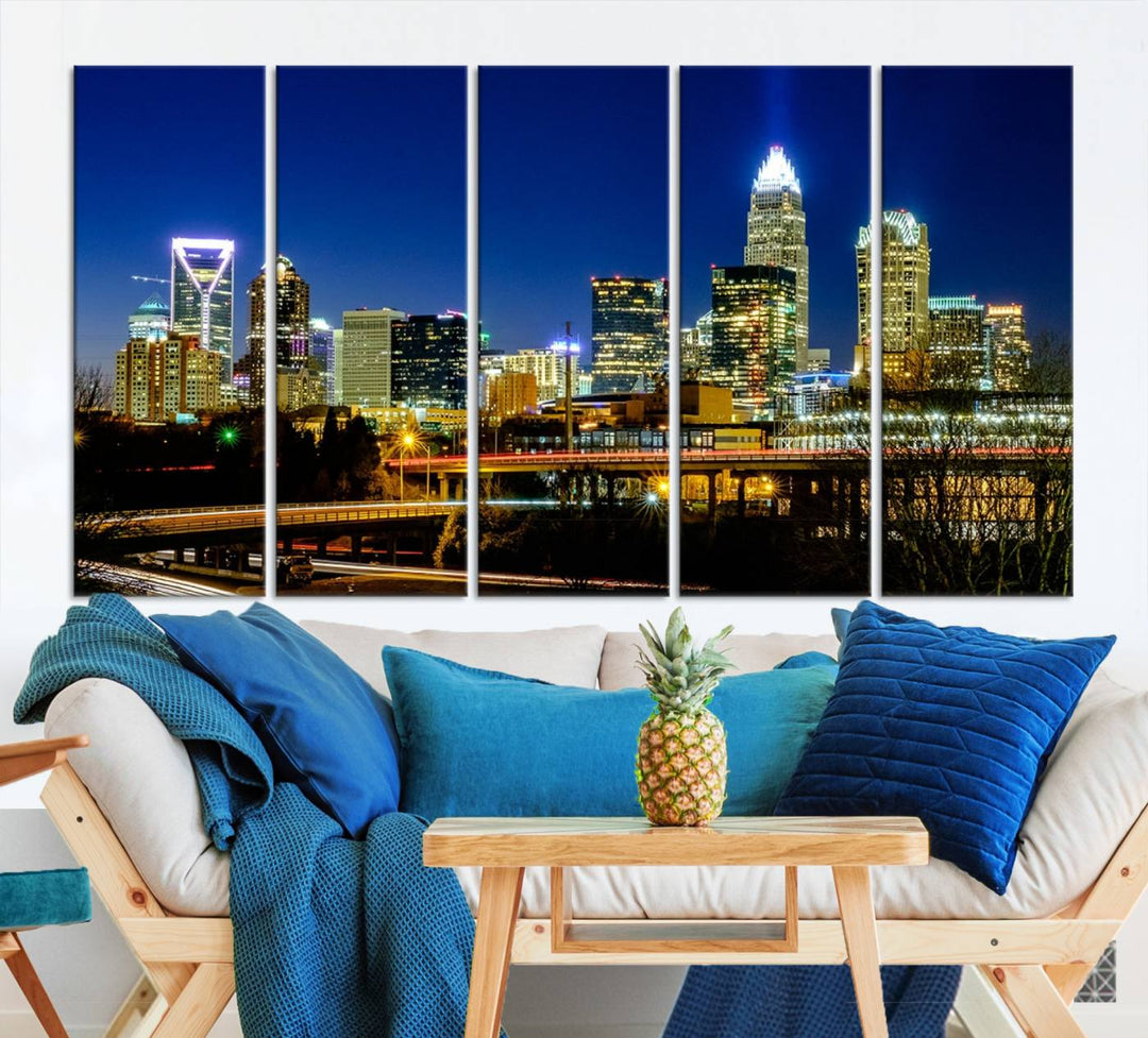 The Charlotte City Lights Night Blue Skyline Cityscape View Wall Art Canvas Print, showcasing an illuminated city skyline at night, is printed on museum-quality canvas with a UV-protective coating. Enhance your space with this stunning piece and enjoy free shipping with your purchase.