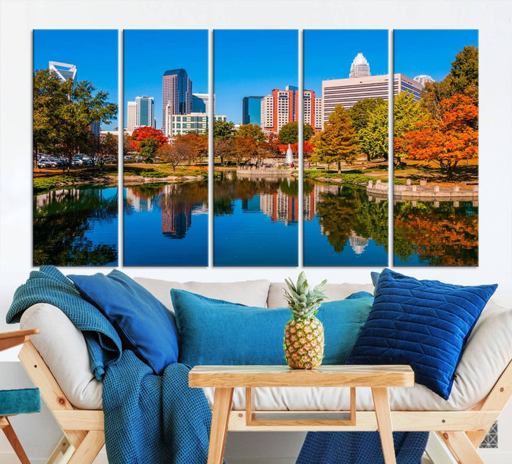 The "Charlotte City Autumn Morning Blue Skyline Cityscape View Wall Art Canvas Print" showcases a cityscape with vibrant autumn trees reflected in a lake. Its gallery-wrapped edges add depth to the scene, while the UV-protective coating ensures lasting brilliance.