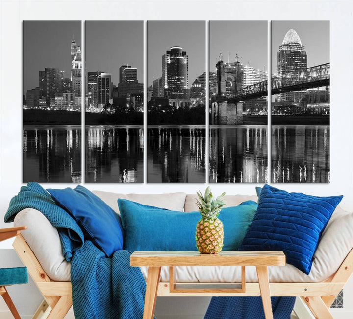 The wall showcases a ready-to-hang triptych of the Cincinnati City Lights Skyline in black and white, printed on museum-quality canvas.