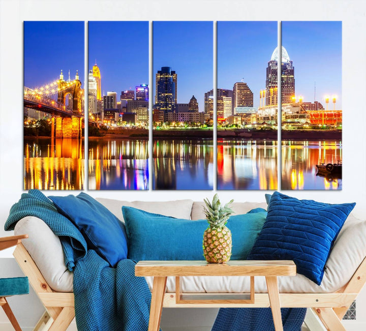 The "Cincinnati City Lights Night Skyline Cityscape View Wall Art Canvas Print" is a gallery-wrapped, museum-quality canvas illustrating a lit-up bridge and skyline at night. Enhanced with a UV-protective coating, this piece ensures lasting vibrancy.