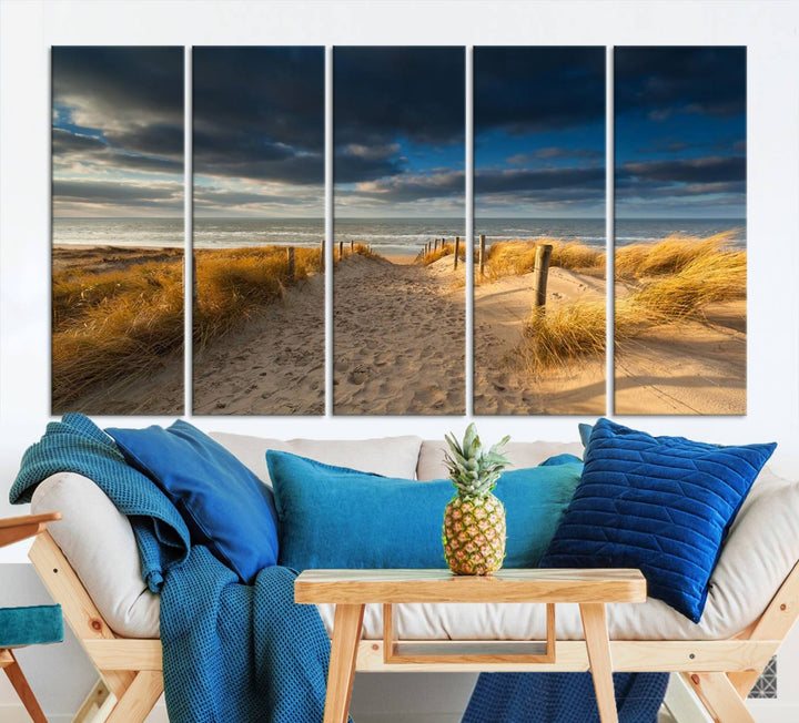 The Ocean Beach Dark Clouds Wall Art Canvas Print is a breathtaking triptych depicting a sandy beach path with tall grasses under an intense cloudy sky. It is crafted on museum-quality canvas with UV protection.