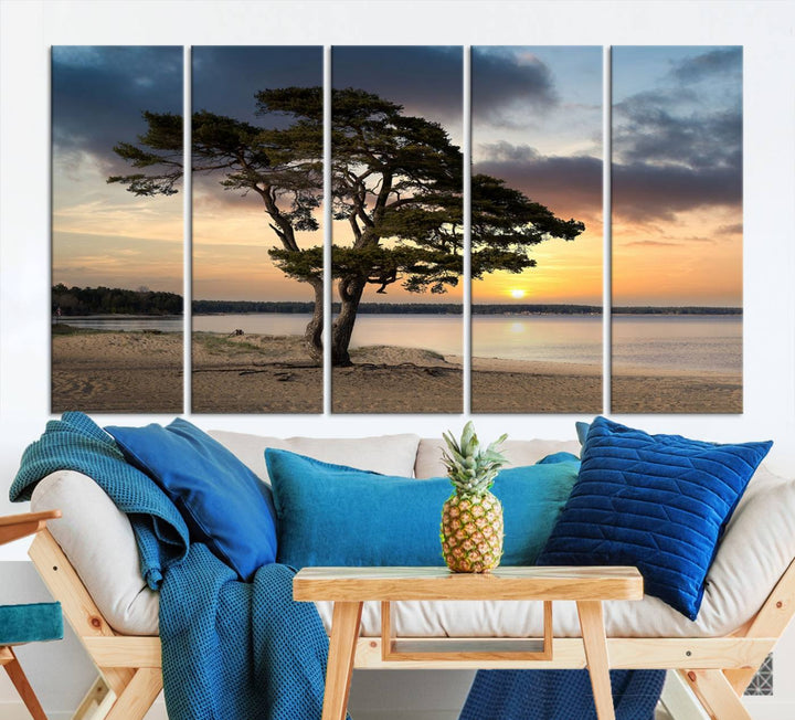 The room showcases the Coastal Sunset Wall Art Canvas Print, a triptych elegantly displayed on museum-quality polycotton canvas, depicting a serene beach sunset with a tree.