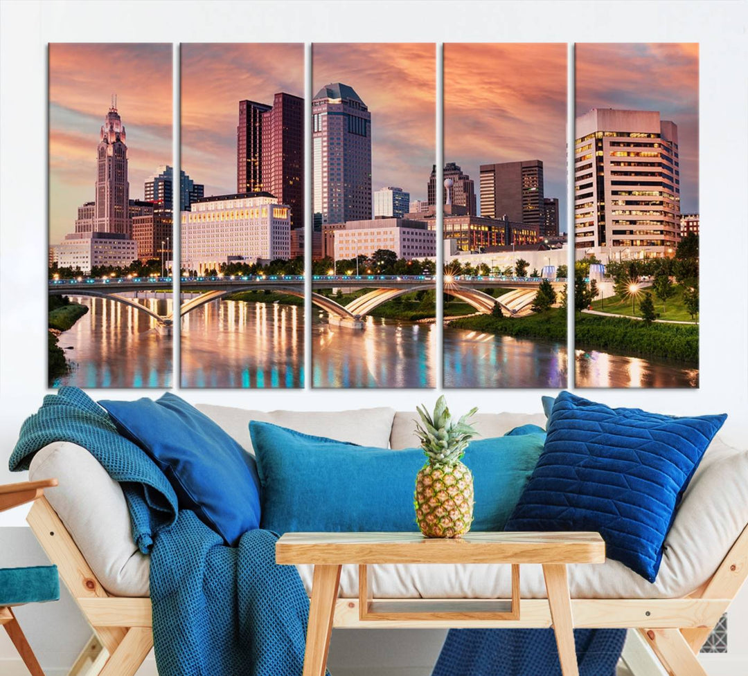 The "Columbus City Lights Sunset Orange Cloudy Skyline Cityscape View" wall art is featured on the wall. This triptych is printed on museum-quality canvas and includes a UV-protective coating, ensuring lasting vibrancy.