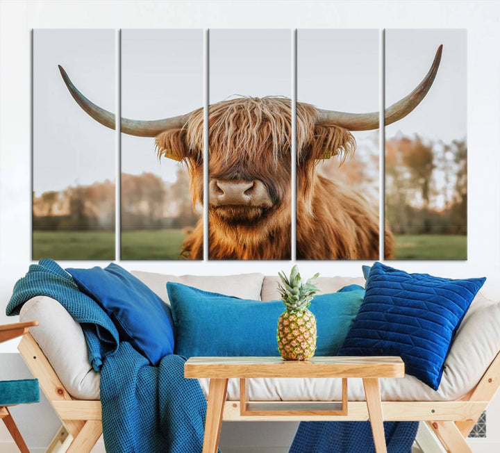 A Highland Cow Animal Scottish Cattle Art Print Farmhouse Wall Art Canvas Print hangs in the living room, adding a touch of rustic farmhouse decor.