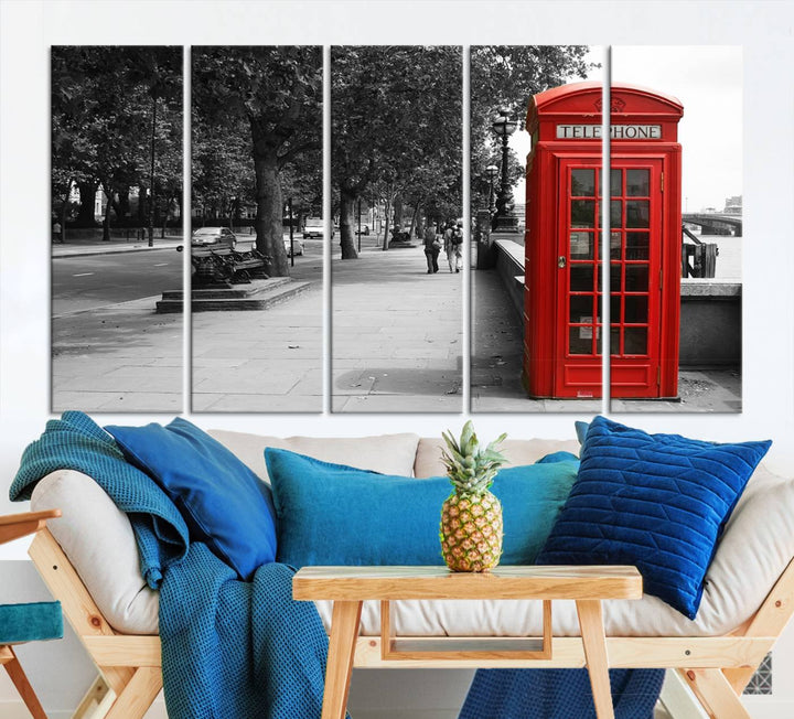 The London Phone Club Wall Art is a stunning piece that showcases a red telephone box set in a black and white street scene on museum-quality canvas. It is gallery wrapped with a UV-protective coating to preserve its vibrant charm.