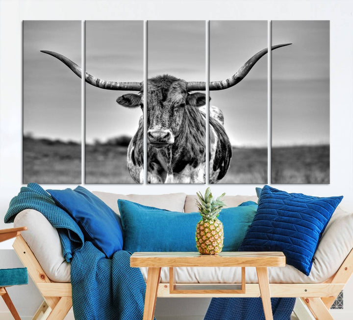 The Texas Longhorn Cow Wall Art, featuring a black and white image of a longhorn bull on canvas, brings charm to the room with its sophisticated appeal.