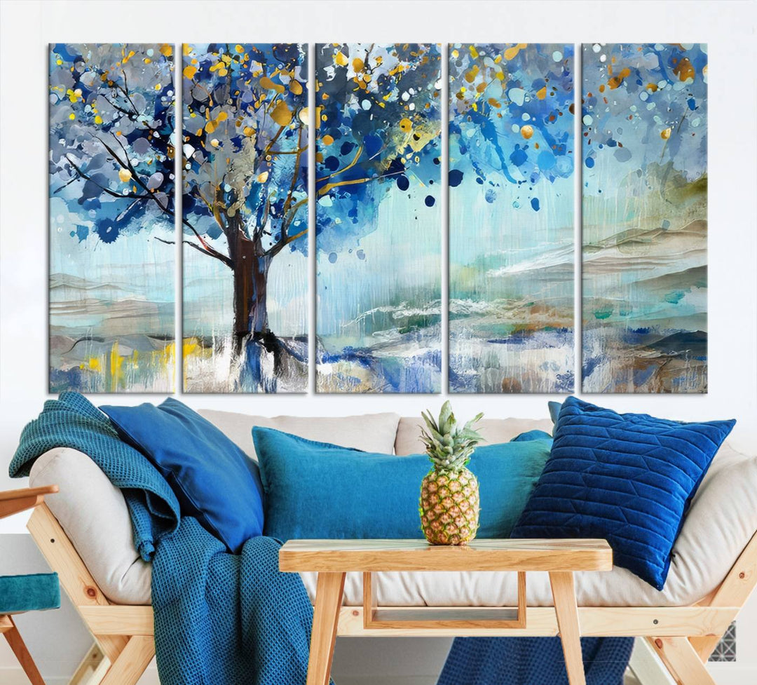 A modern living room features a three-panel Watercolor Style Abstract Tree Printing Wall Art Canvas in vibrant blue and yellow, crafted on museum-quality material.