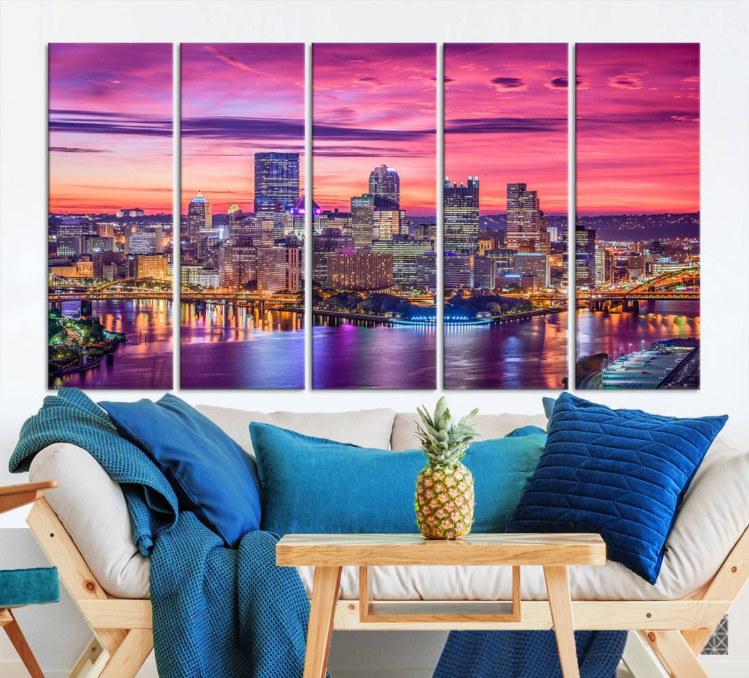 The Pittsburg Wall Art Canvas Print, showcasing a vibrant sunset glow over the city skyline and crafted by a professional artisan, adorns the space.