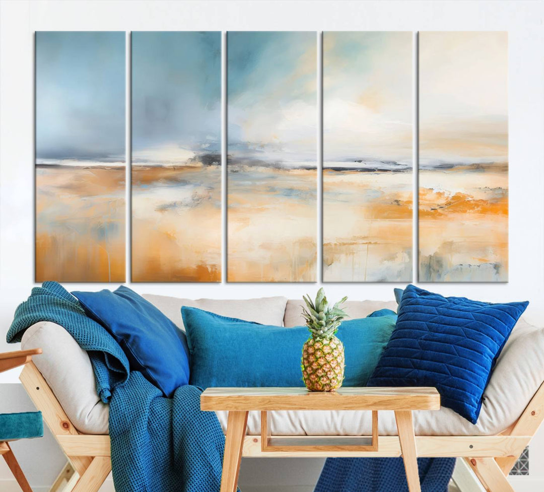 The Abstract Landscape Wall Art Canvas Print, featuring warm tones of orange and blue, is displayed on a dark wall.