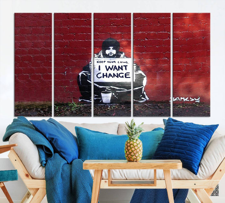 The living room showcases a triptych of stencil artwork on museum-quality canvas, featuring the Banksy I Want Change Graffiti Abstract Wall Art Canvas Print. This captivating piece depicts a person holding a sign that says "I want change" and is finished with a UV-protective coating to ensure long-lasting beauty.